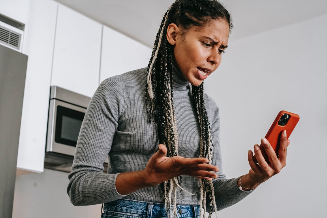 Image of a woman who is angry looking at her phone