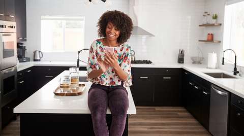 About our mortgage partnership Woman on smart phone in kitchen